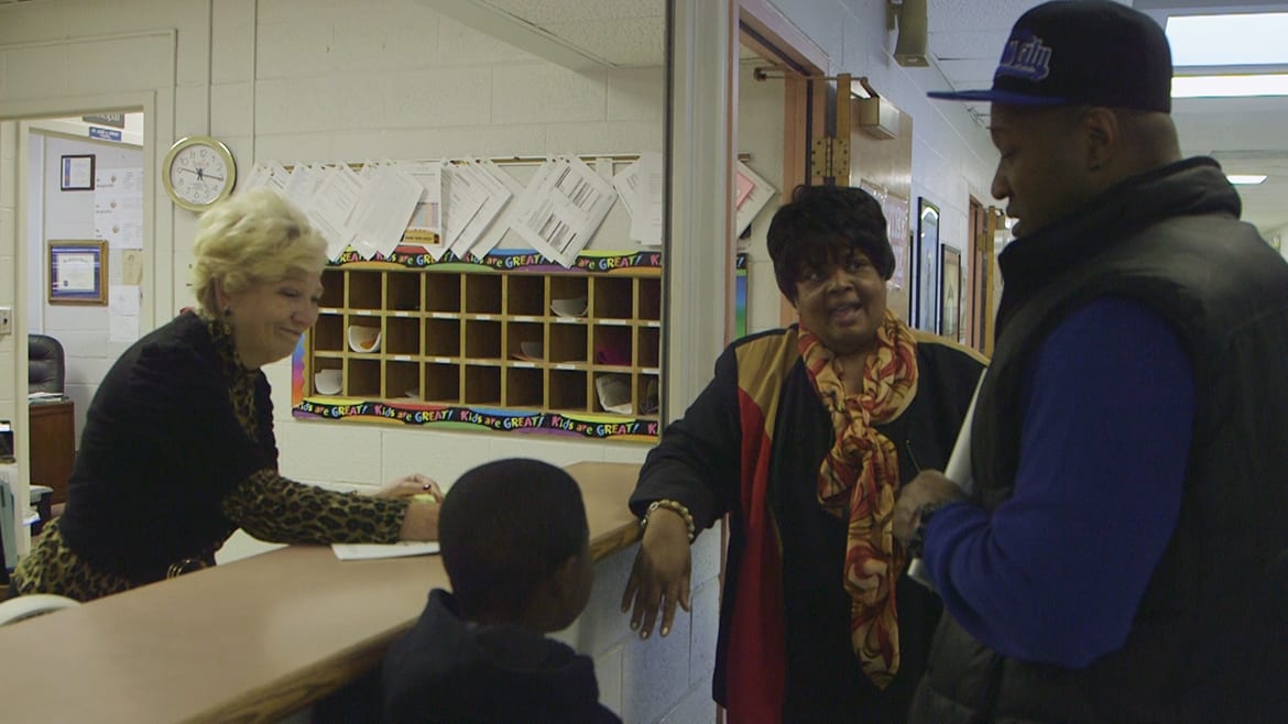 Principal Kirksey and office staff greet a new student and his father at Hartman Elementary.