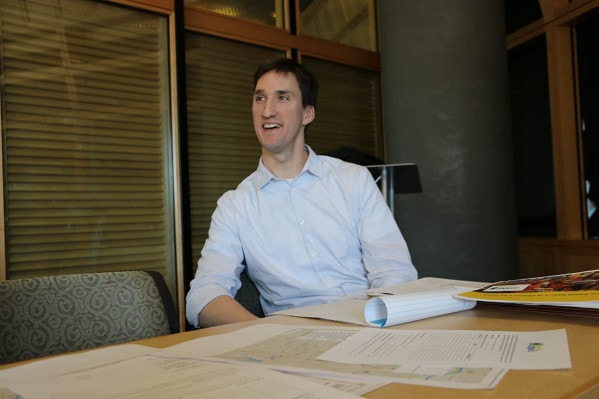 Picture of Mike English sitting at conference table with papers sprawled in front of him