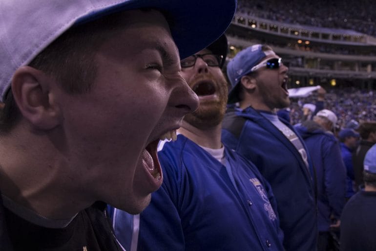 Photo of Royals fans at a game shouting and celebrating.