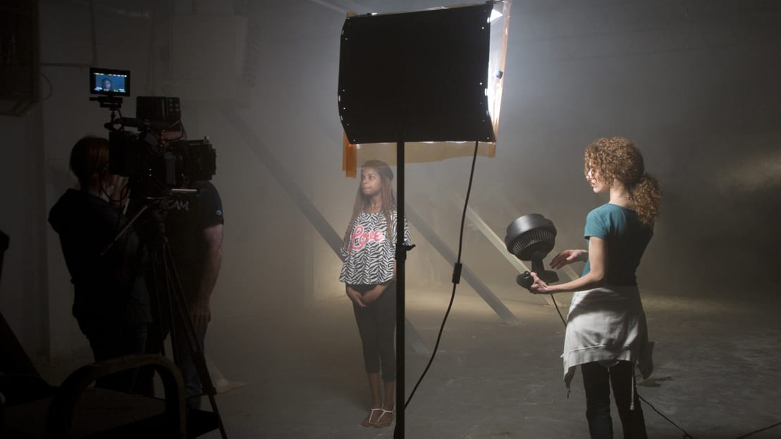 Image of woman being filmed on set.