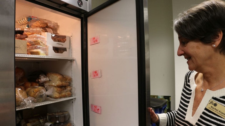 Rachel Krantz opens the refrigerator that holds much of the JFS food pantry's perishable food. (Photo by Bridgit Bowden/Hale Center for Journalism)