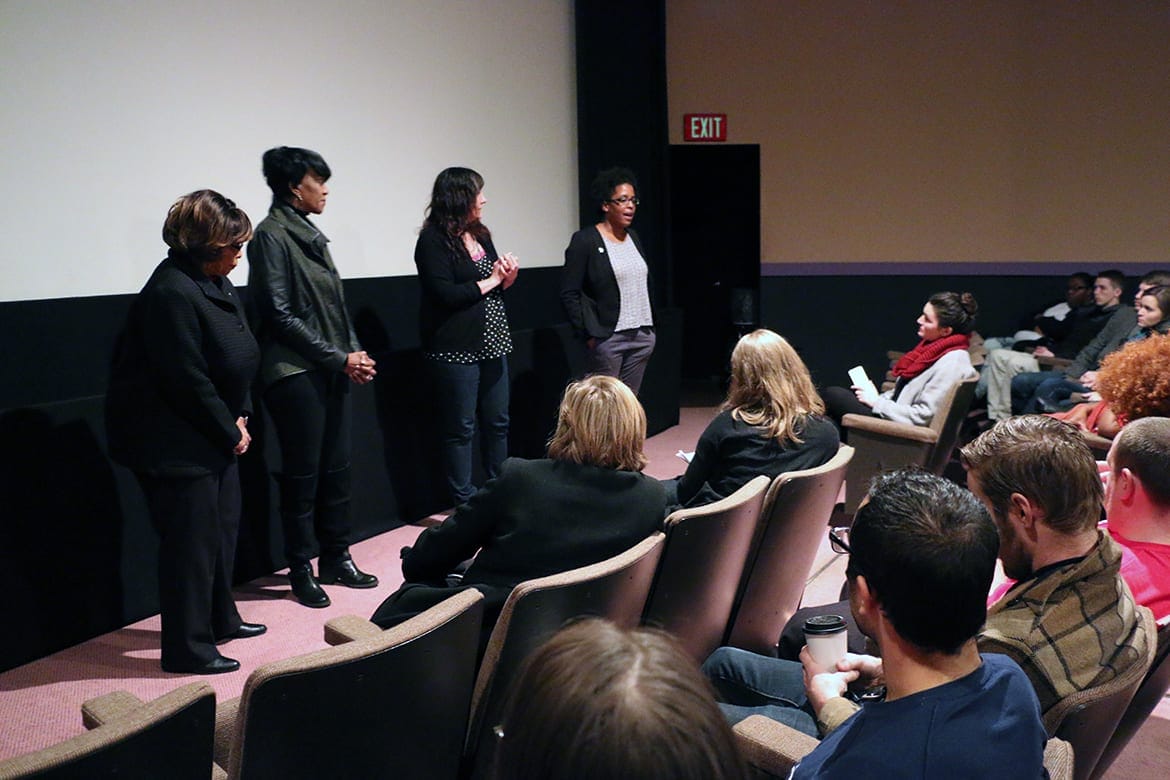 Image of people standing at front of theater talking to the audience.
