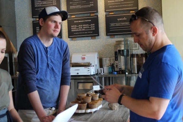 Heirloom Bakery owner Scott Meinke helps a customer choose from their locally-sourced menu. (Photo: Eleanor Klibanoff/KCUR)