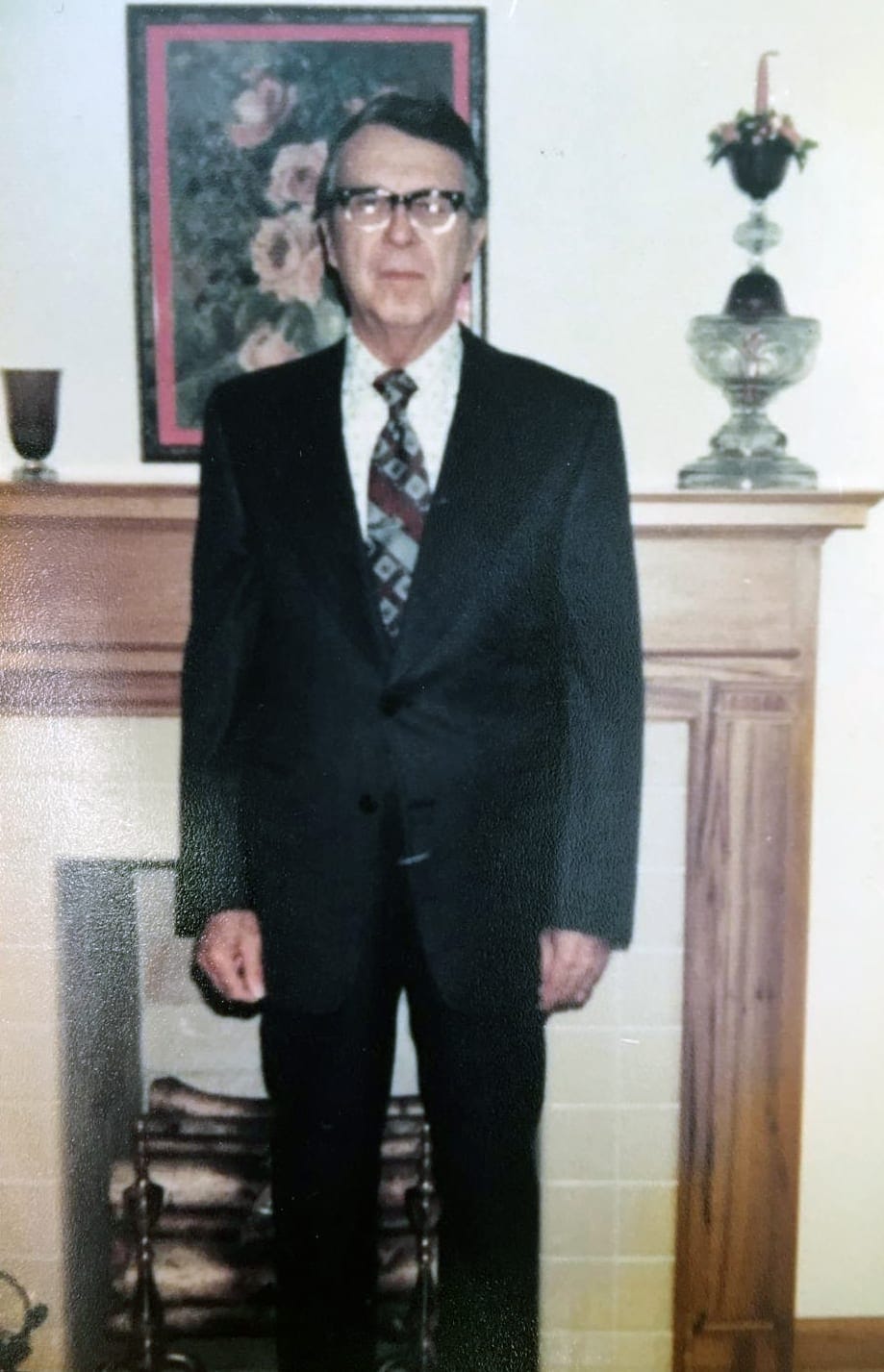 A man in front of a fireplace