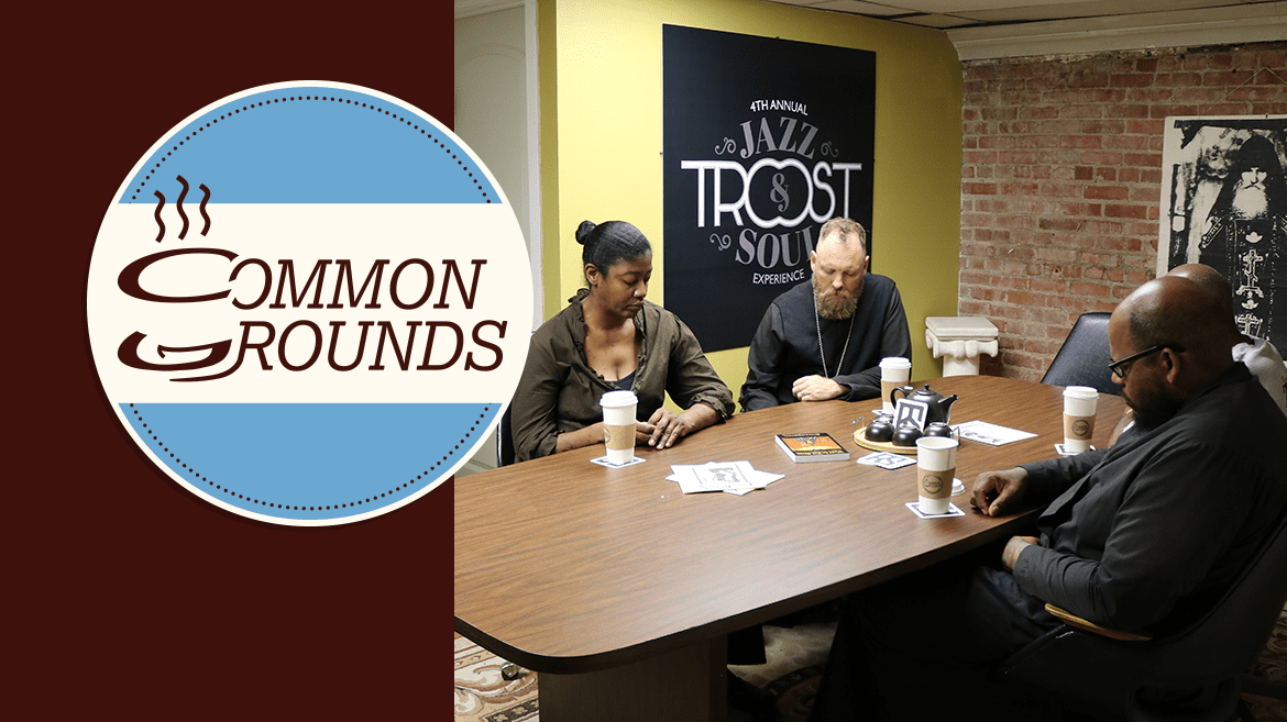 A group of people gather over coffee in prayer