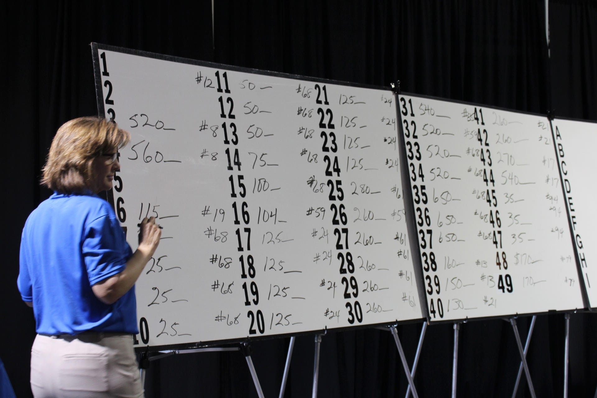 A woman stands next to a presentation.
