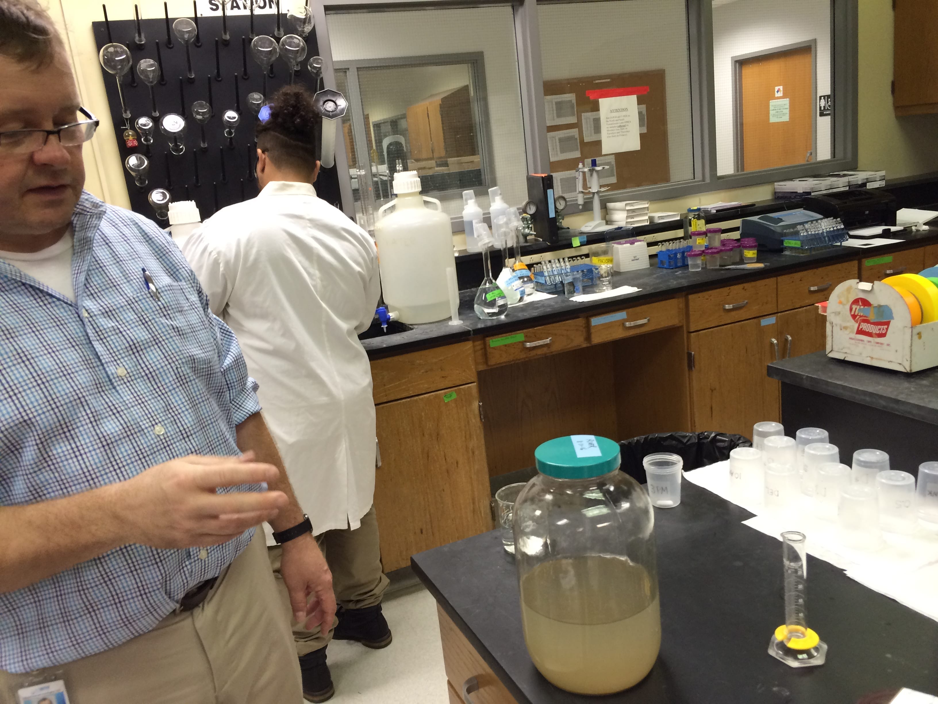 A man points to a jar of water.