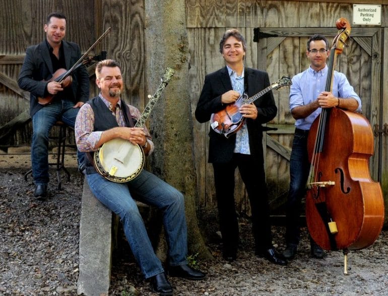 A bluegrass band posing with their instruments.