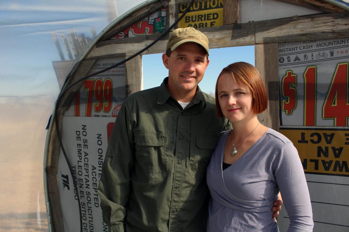 A man and woman standing on their farm.