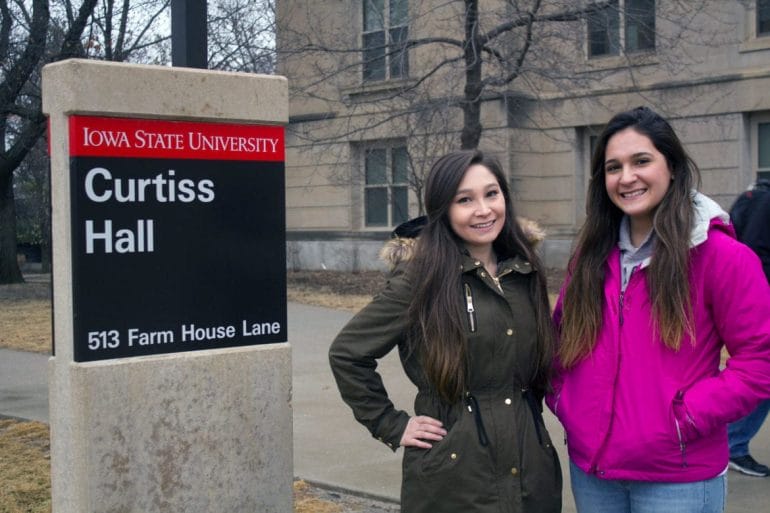 Two women standing on a college campus.