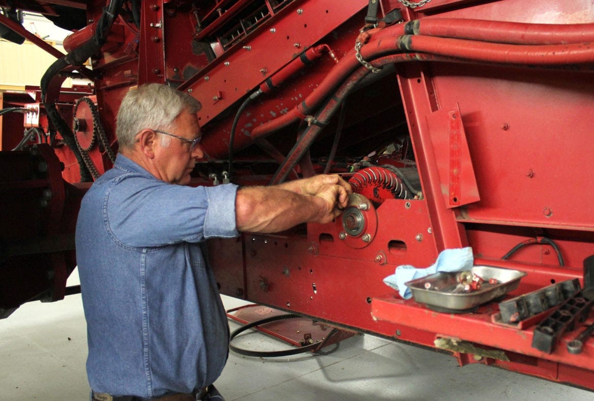 A man working on a tractor combine.