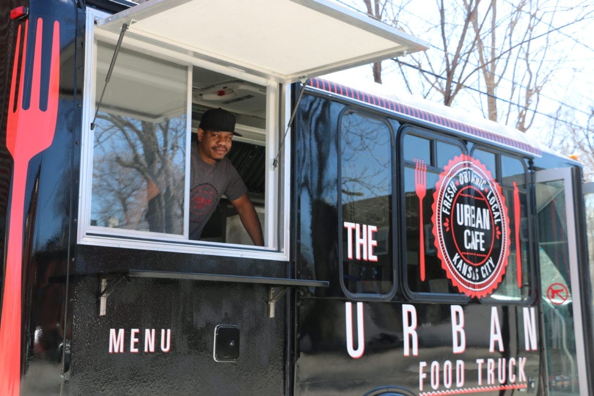 A man ready to serve food out of his food truck.