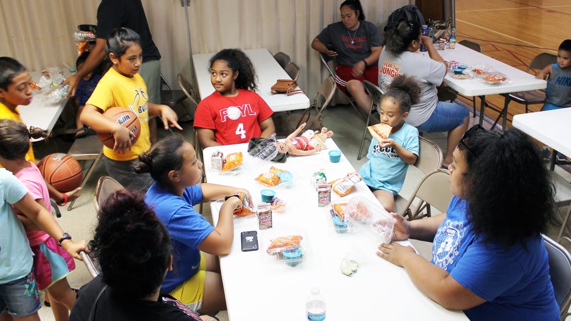 Kids gather in a gym to eat lunch from a government summer food program at Susquehanna Baptist Church, a food site in Independence, Missouri. (Lindsay Huth | Flatland)
