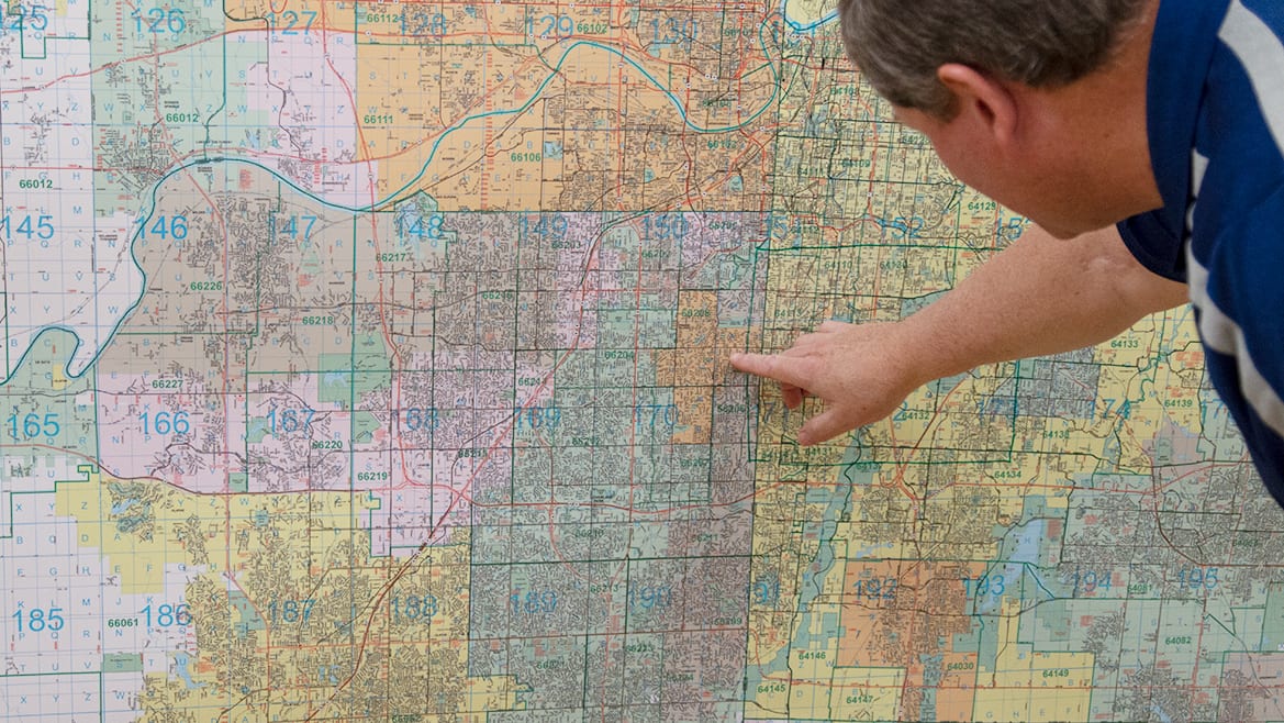 A man looks over a large wall map at Gallup maps in Kansas city