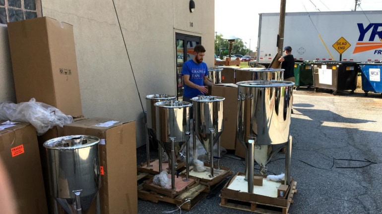 Brian Bixby and Brian Freymuller (back) unpack the fermenters