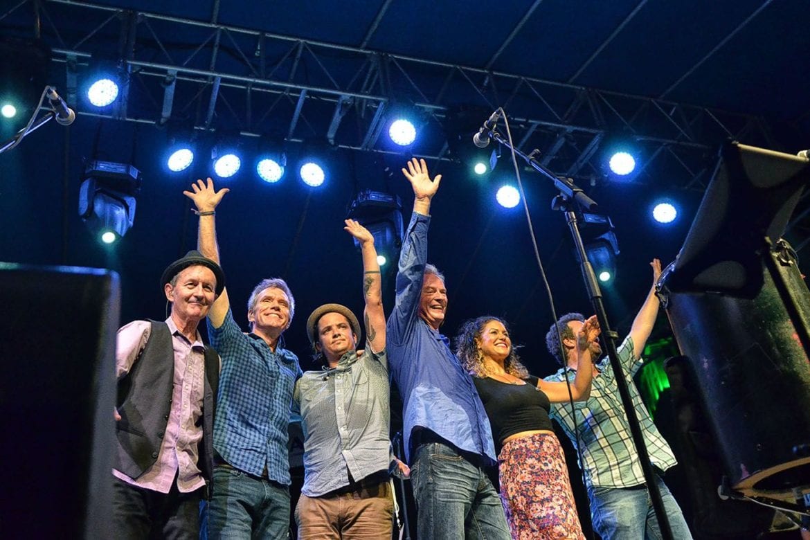 A band waving goodbye on stage.