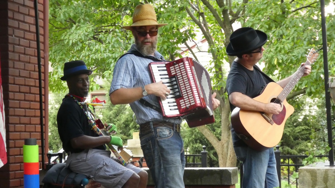 A man plays an accordion with his band.
