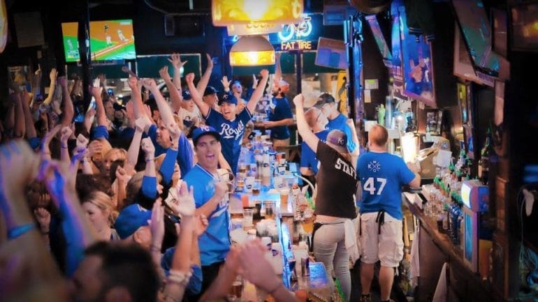 Fans celebrate in a crowded bar.