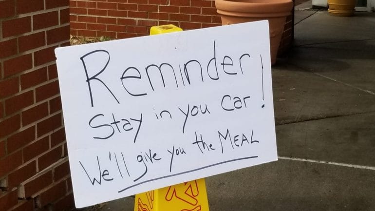 A sign at Don Bosco Senior Center urges clients to stay in their cars. 