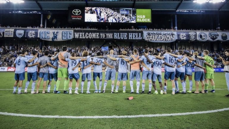 The Sporting Kansas City soccer team lines up and locks arms in front of the home crowd