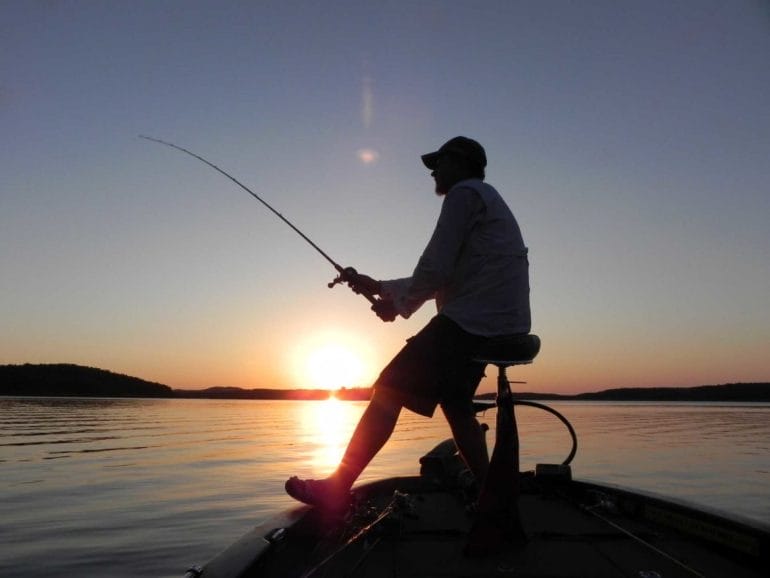 A fisherman at sundown on the lake.