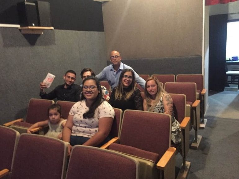Yosmel Serrano, pre-pandemic, poses with patrons in his small Latino theater in Northeast Kansas City. He sees his businesses as a way to education the Kansas City community of Spanish-language films. (Contributed)