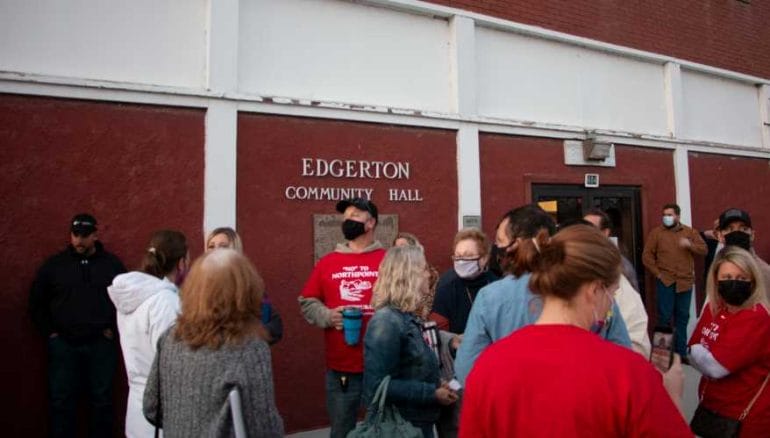 Area residents gather outside of the Edgerton Community Hall on March 11, 2021.
