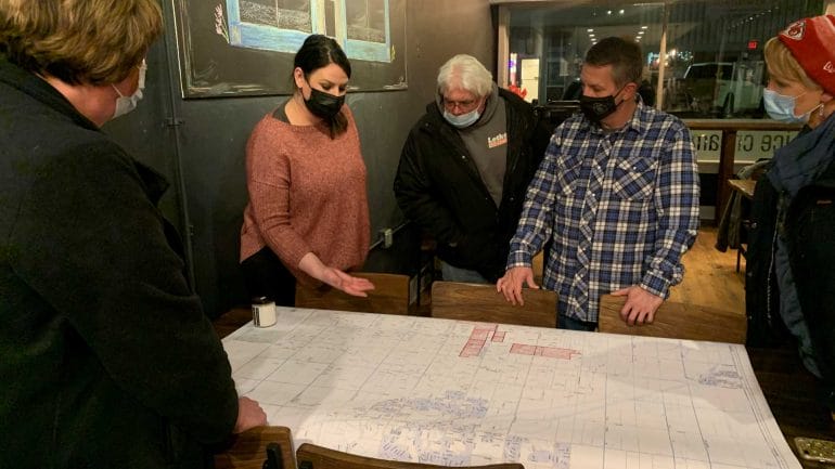 Jenni Koch shows other residents the parcels of land up for rezoning at The Coffee Bean Co. in Spring Hill, Kansas, on Feb. 9, 2021.