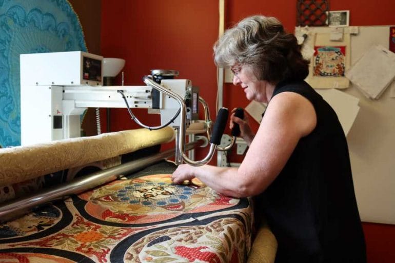 Robyn Gragg uses her long-arm sewing machine to make intricate quilting designs. Robyn Gragg uses her long-arm sewing machine to make intricate quilting designs.
