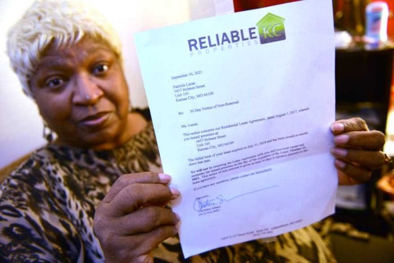 Tenant Pat Lucas displays the note she received informing her that she would need to be out of her apartment by November 1.