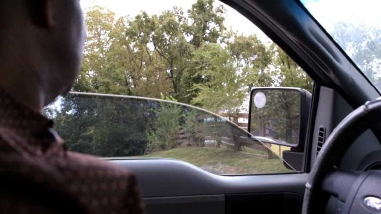 Phil Dixon drives past the remains of a fence that was erected to separate Black and white communities in Rattlebone Hollow.