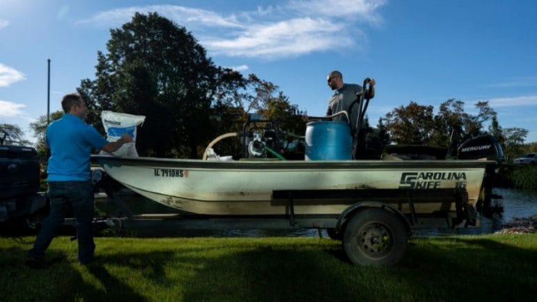 T.J. McCloud (left) and Chris Hoffman (right), prepare a bentonite clay solution to treat a pond at 3850 N Wilke Rd, Arlington Heights, Illinois, on Tuesday, Oct. 19, 2021.