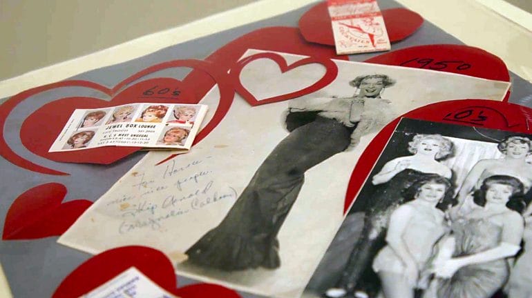 A smattering of photos, pamphlets and cut-out paper hearts frame images of "female impersonators" of the 1950s. This is part of the GLAMA Archives collection. Image by Cody Boston