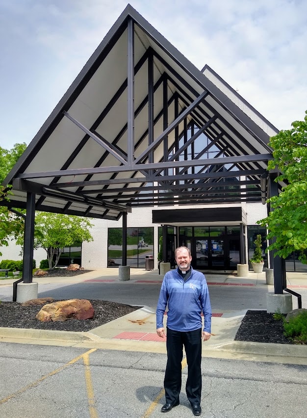 Fr. Justin Hoye outside the front entrance of St. Thomas More Catholic Church.