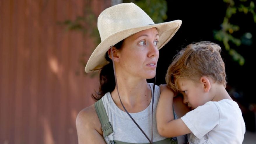 Jordan Welch embraces her son Jentry outside the equipment shed on July 20 in Concordia.