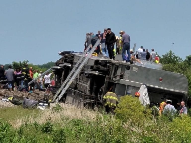 People outside of a crashed Amtrak train car.
