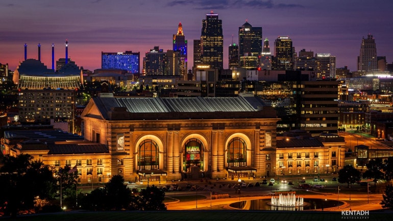 Union Station at night with the downtown skyline in the background.