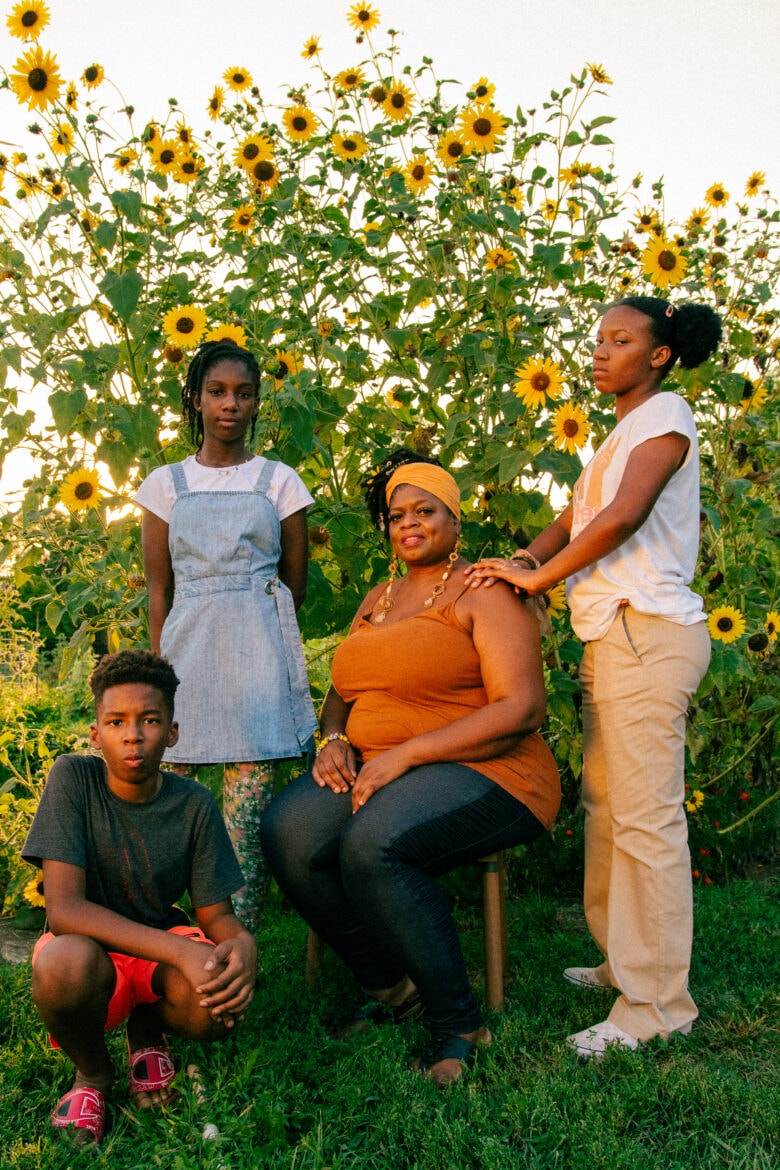 August's garden therapy crew stands against a backdrop of sunflowers. (Clockwise from left) Riyad Ba, 11, Zara Ba, 13, Denise Perkins at center and Liberty Williams, 13, before began. (Ji Stribling | Flatland))