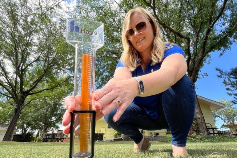 Hays gives out rain gauges, like the one Holly Dickman holds here, to every new resident as part of a welcome basket. The idea is to help residents know when the rainfall brings enough moisture to skip watering their lawn.