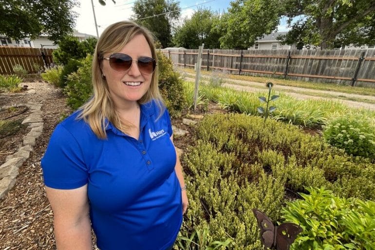 Hays water conservation specialist Holly Dickman stands in a yard that won the town's conservation award a couple of years ago. It shows an example of using drought-tolerant plants to replace grass.