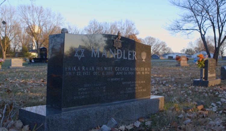 A granite headstone reads "Mandler" and shows a Star of David and Menorah. A plaque dedicates "Holocaust Survivor"