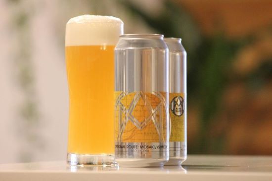 A glass and two cans of Alma Mader's new pale ale.
