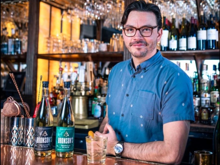 Bronson Kistler standing behind a bar.