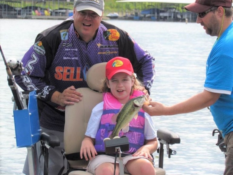J.P. Sell (left) is happiest when he helps young disabled anglers such as Courtney catch their first fish. During a special event for kids with physical and mental disabilities, Sell's friend, James Boothe, assisted.