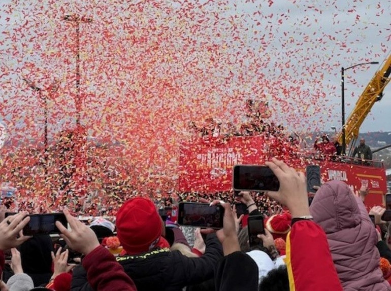 A blizzard of red and gold confetti engulfs the players atop a bus during the Kansas City Chiefs Super Bowl championship parade.