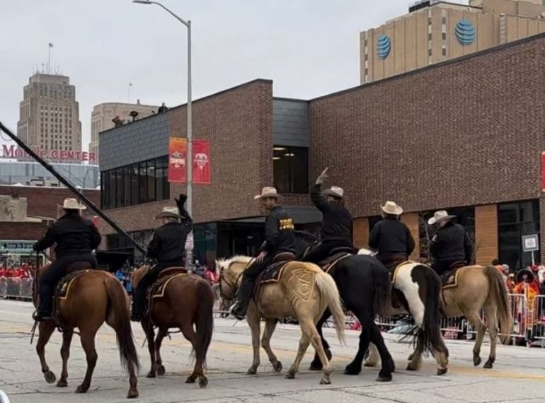 Riders on horses traverse Grand Boulevard during the Kansas City Chiefs Super Bowl championship parade.