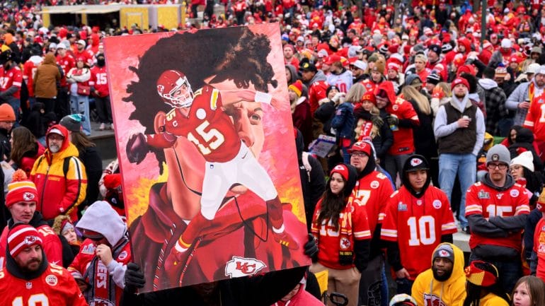A man carries a portrait of Kansas City Chiefs quarterback Patrick Mahomes through the crowd during the Chiefs' victory celebration and parade in Kansas City, Mo., Wednesday, Feb. 15, 2023. The Chiefs defeated the Philadelphia Eagles Sunday in the NFL Super Bowl 57 football game.