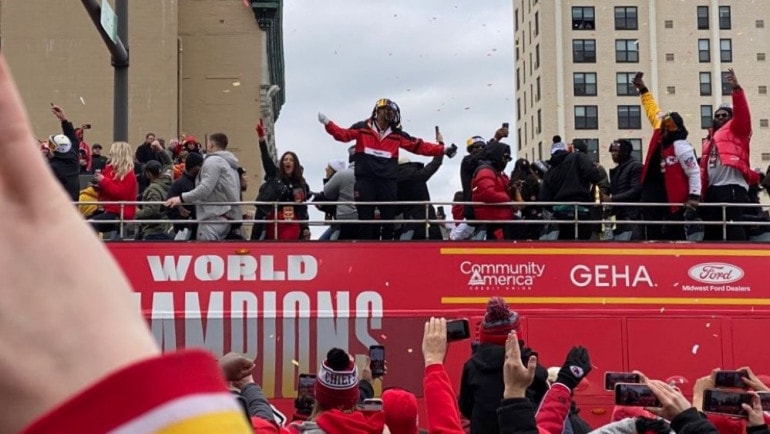 Chiefs players atop a bus greet fans along Grand Boulevard during the Kansas City Chiefs Super Bowl championship parade.
