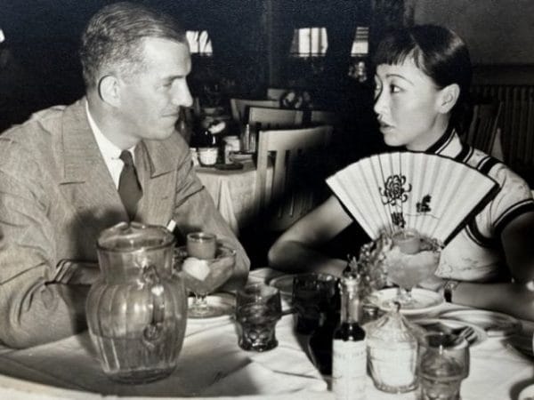 Landon Laird sitting at a table with Anna May Wong in 1937.