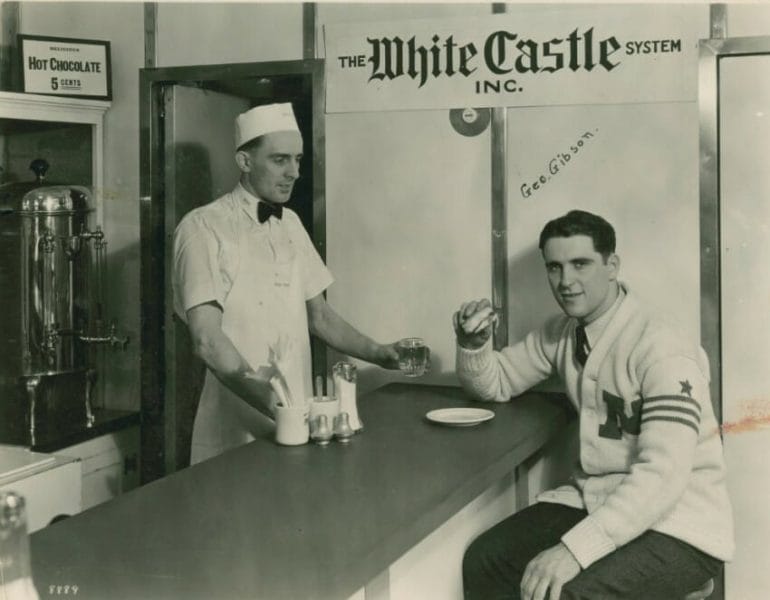A customer in a letter sweater sitting at a White Castle counter.